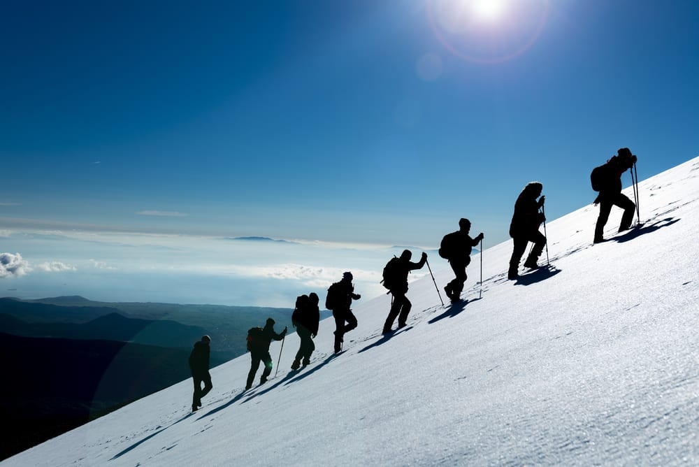 mountain climbers standing in one line conquering nature ice snow challenge climbing up