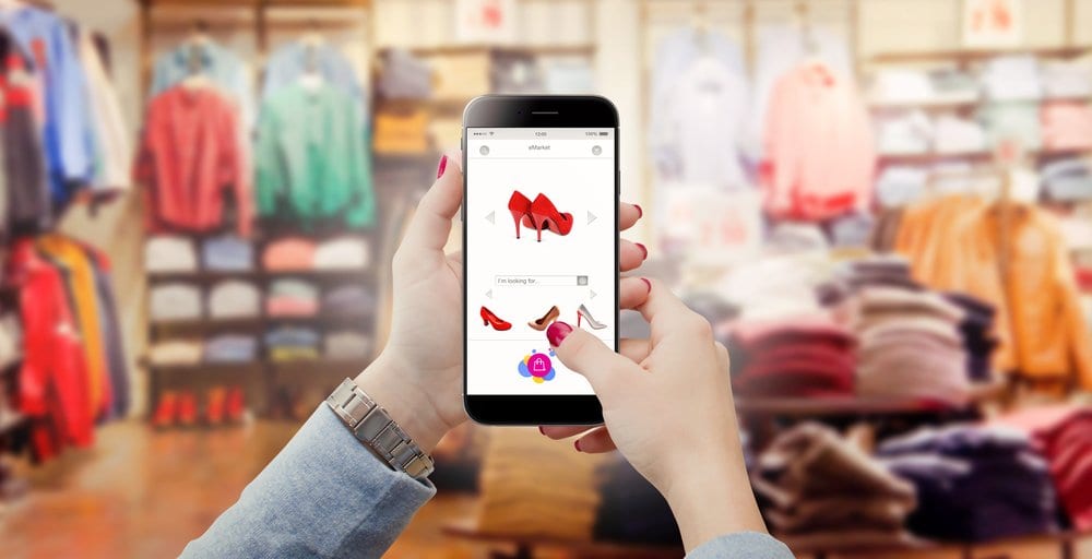 hand held with phone device online shopping commerce concept in clothes store