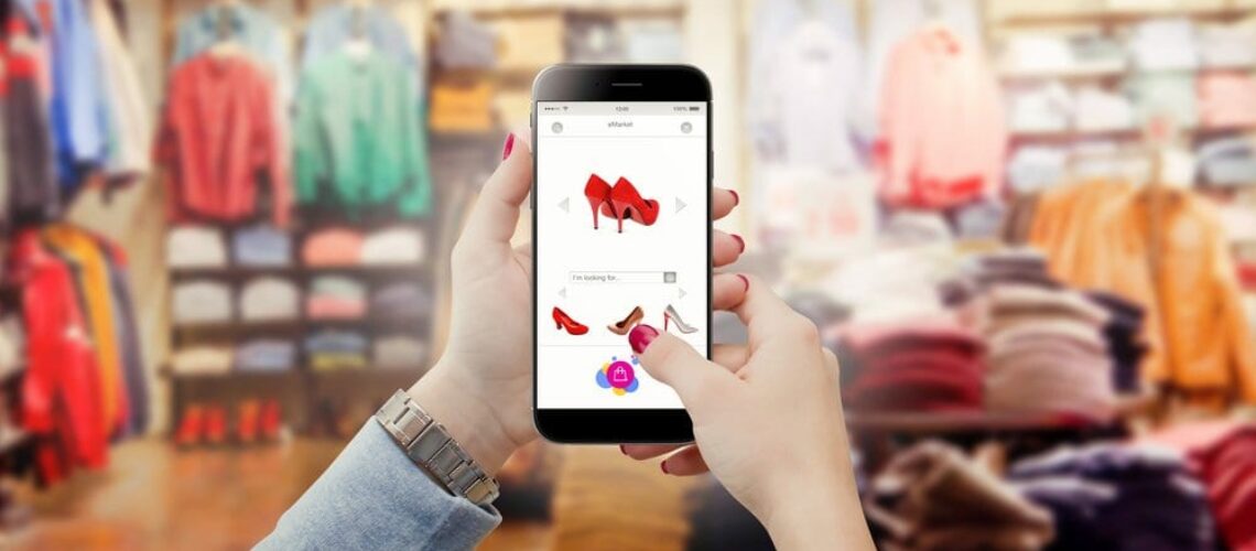 hand held with phone device online shopping commerce concept in clothes store